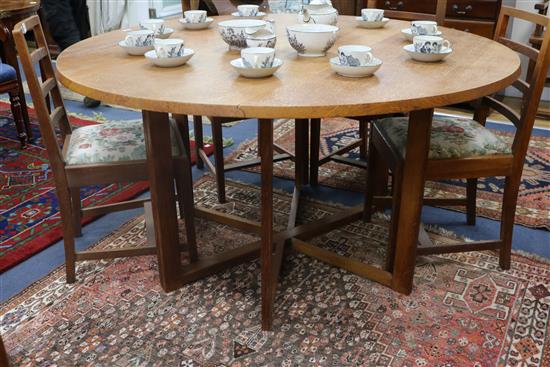 A Gordon Russell oak circular drop leaf dining table with gate leg action underframe Top 143cm Diameter